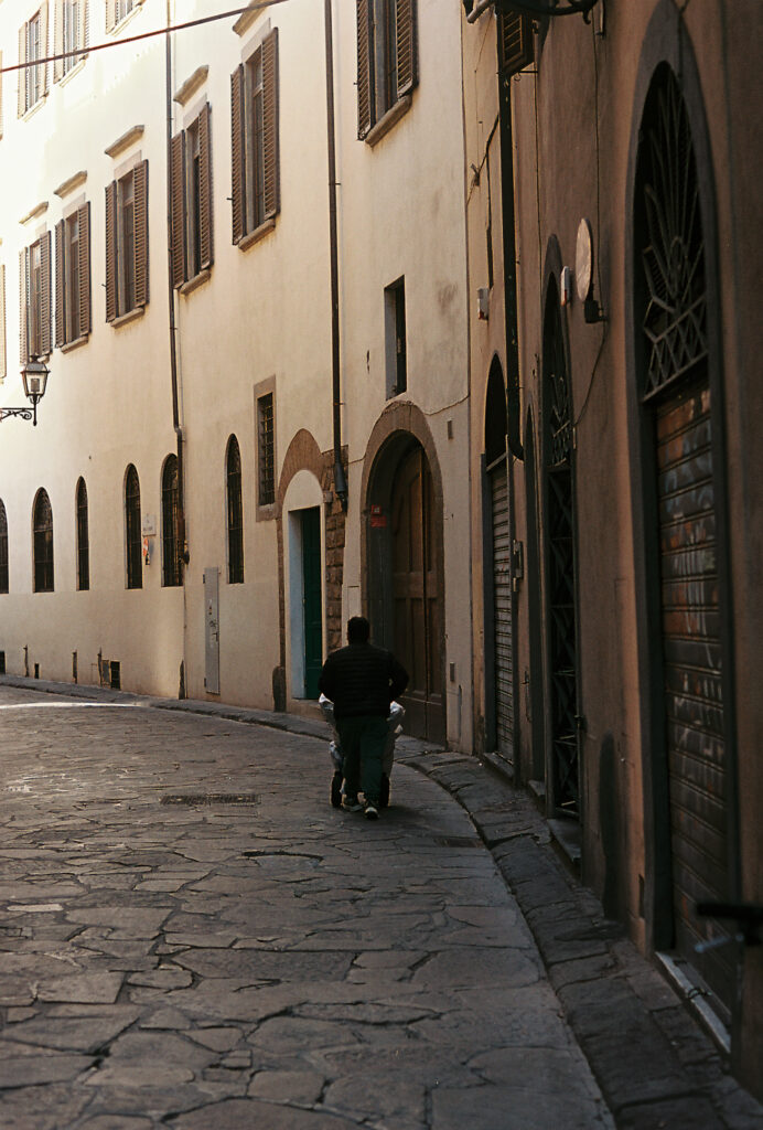 A view down a narrow street where sunlight barely reaches.