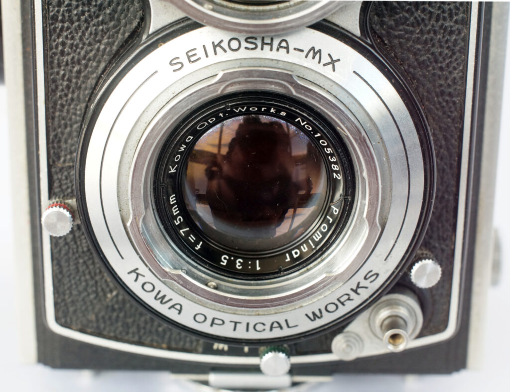 The lens and shutter with the aperture and shutter speed click stopped levers either side of the lens.