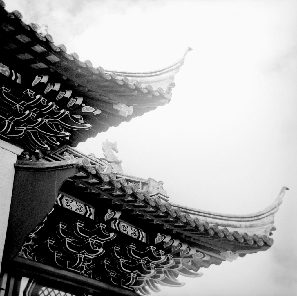 Detail of Entrance arch at Dunedin’s Chinese Gardens with flare apparent. The feature image is not affected. Red filter in both.