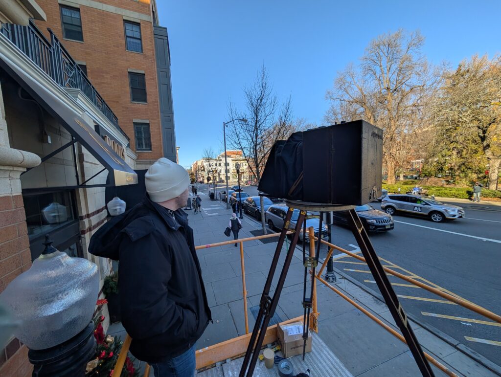 The photographers and camera atop the scaffolding, re-creating the original photograph.