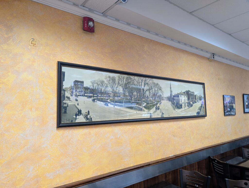 A vintage panoramic image of Morristown, NJ hangs on the wall of a local bagel shop.