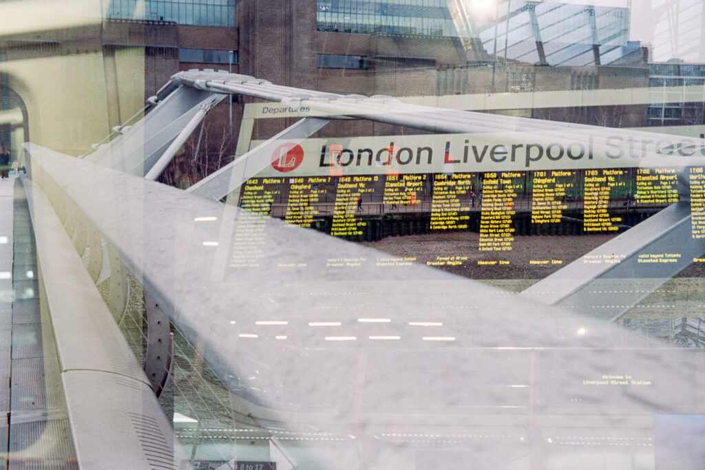 Double exposure featuring Millennium Bridge and the train board at Liverpool Street Station.