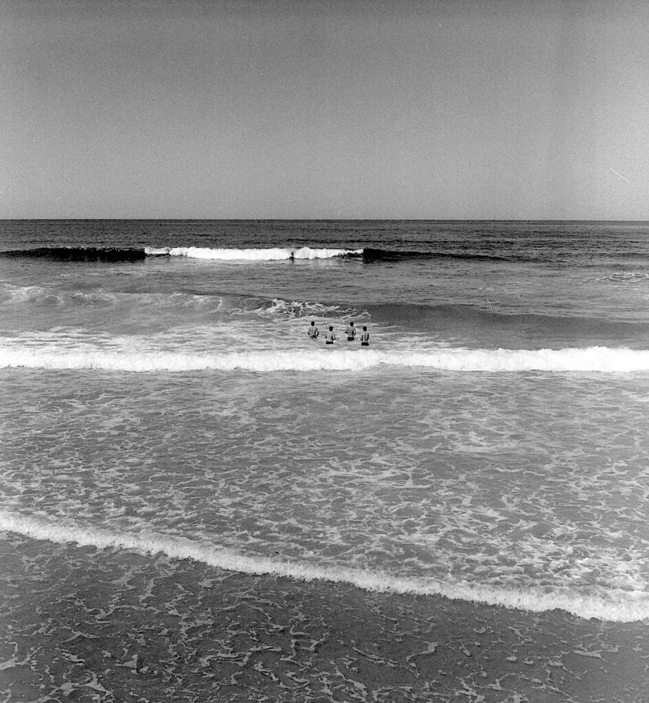 Four men face the mighty Pacific oceon.