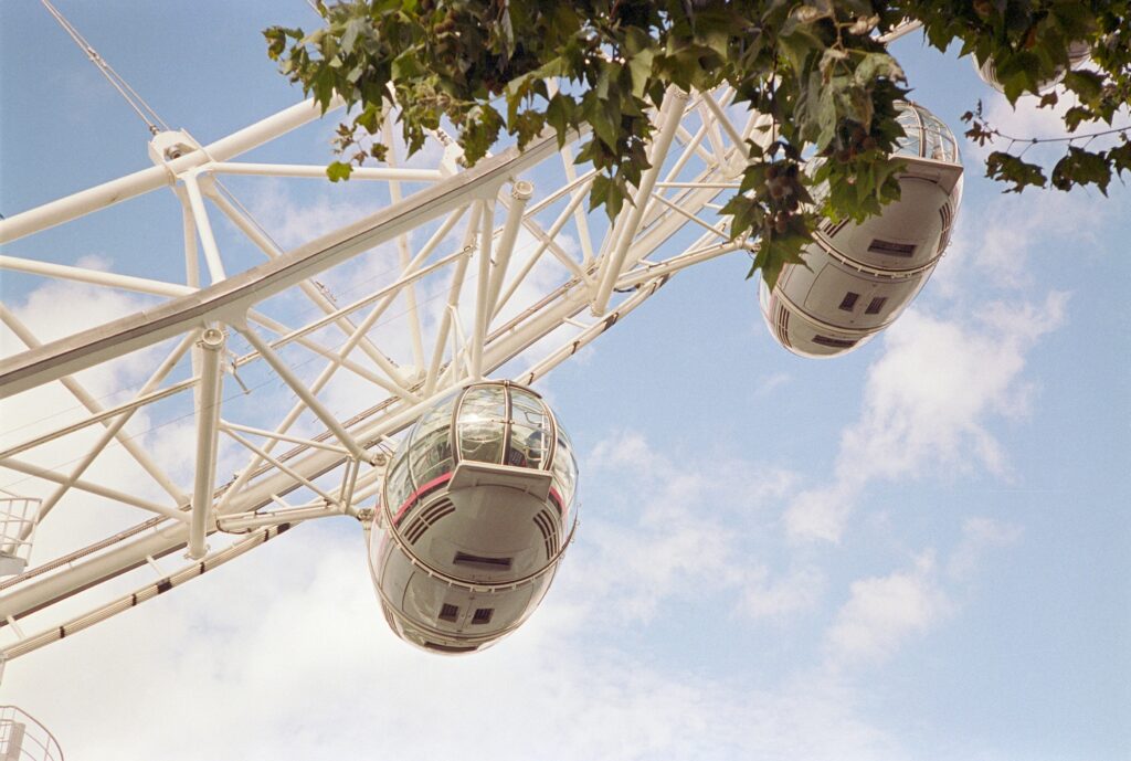 Detail of the London Eye featuring two pods and some tree branches