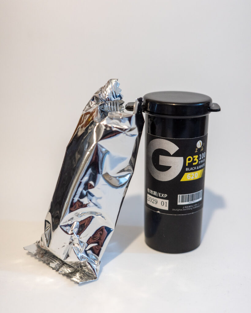 Photo of a plastic tube that holds a roll of 620 film and a roll of 630 film in a foil wrapper.