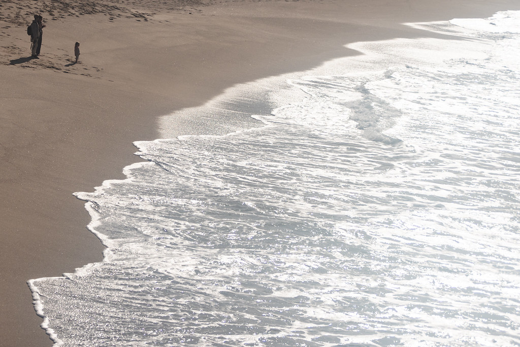 A child looks at the ocean, maybe their first time