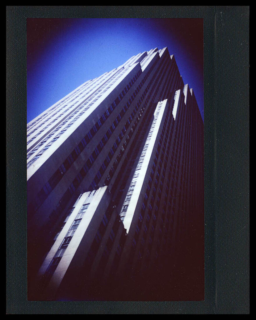 Heavily vignetted Instax Wide image of Thirty Rockefeller Center skyscraper.