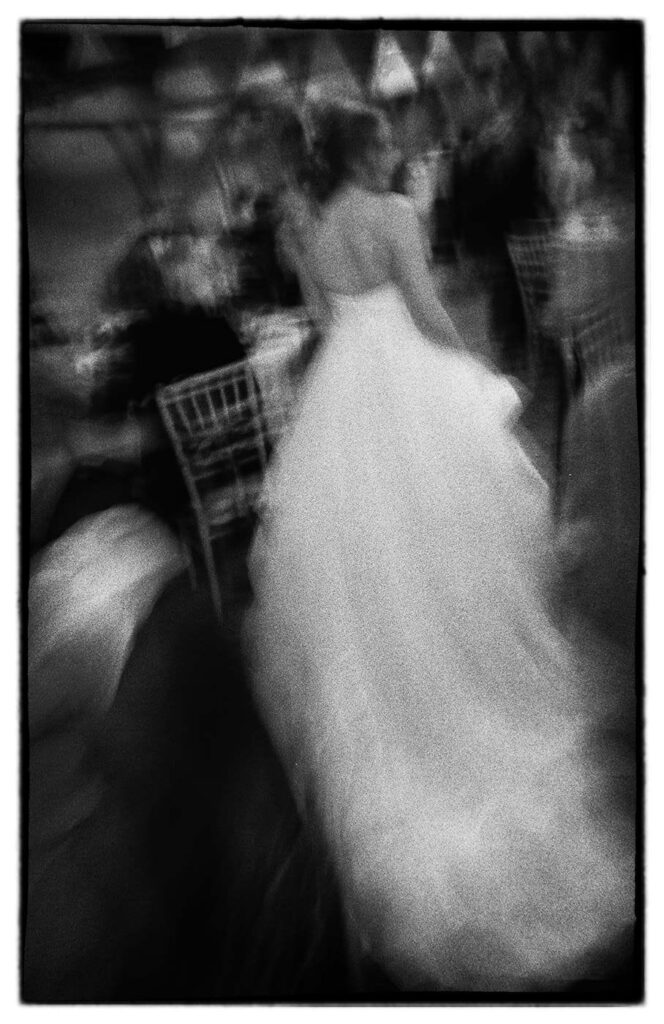 The bride's dress photographed with a slow shutter speed on Ilford HP5 plus film.