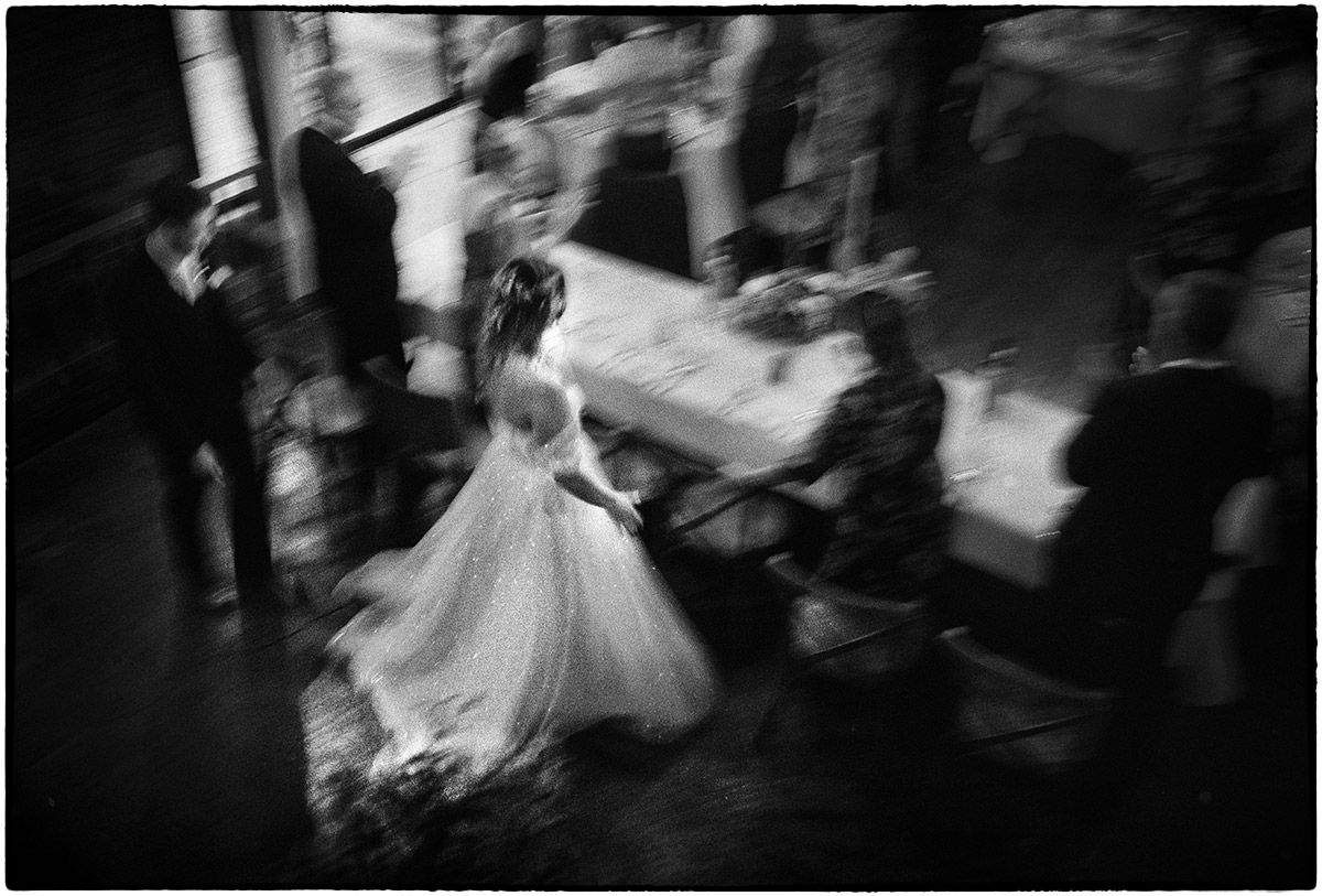 Panning motion blur as the bride and groom enter the wedding reception. Shot on Ilford HP5 plus film.