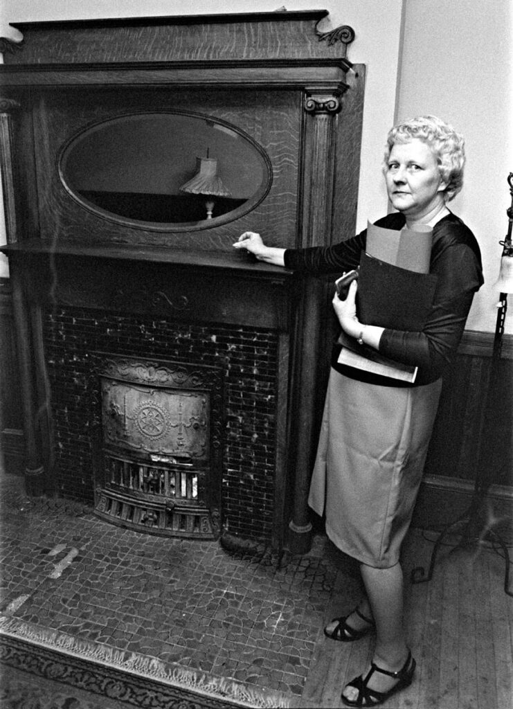 Woman points to fireplace