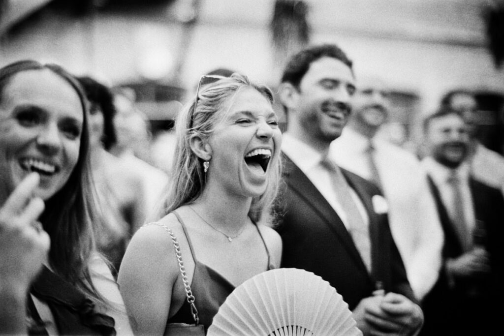 A wedding guest laughing at the speeches, shot with a Leica M4-P camera.
