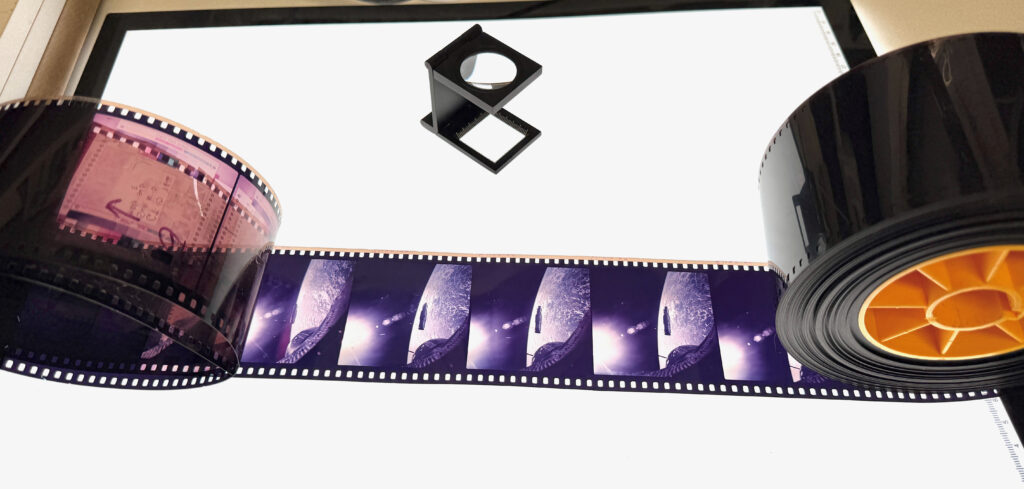 film strip on a bright light pad with a magnifier