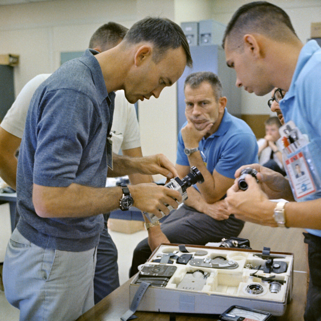 group of men study some old cameras