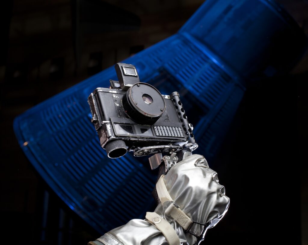 Camera with handle held by a gloved hand