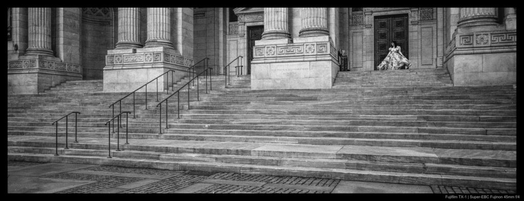 A dancer practices atop the steps of the New York Public Library in Bryant Park. No one else is visible in the early morning.
