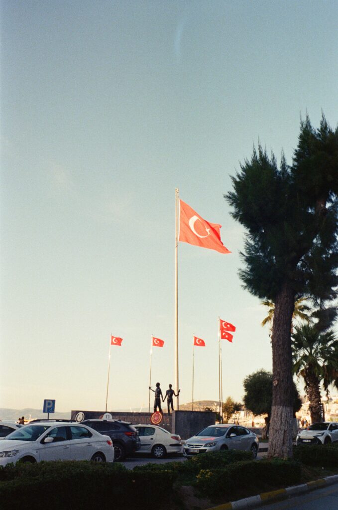 A group of turkish flags in twilight and a road by it 