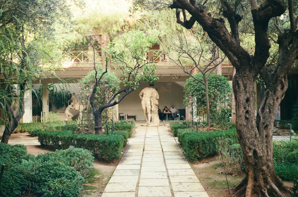 Garden with weathered greek statues and a path