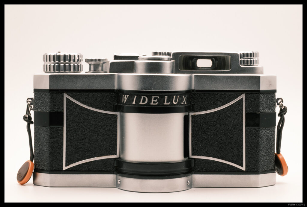 A head-on view of a Panon Widelux F6 in its two-tone black and silver finish
