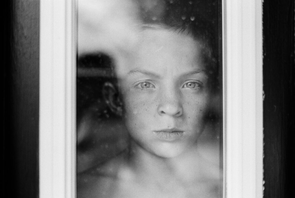 Boy looking through window