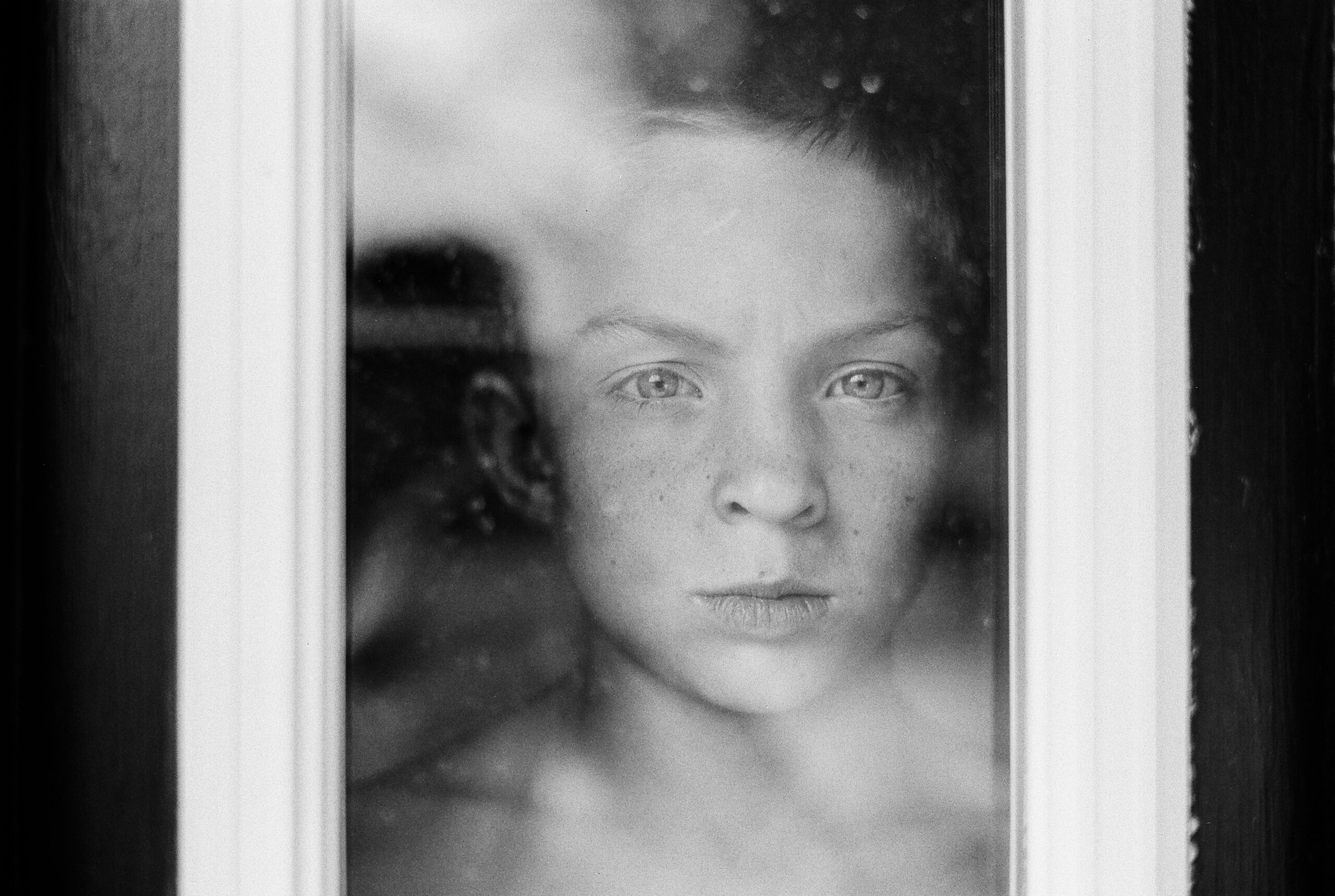 Boy looking through window