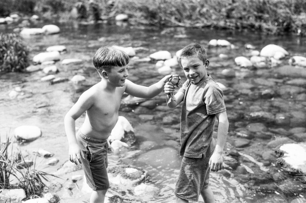 Two boys holding a frog