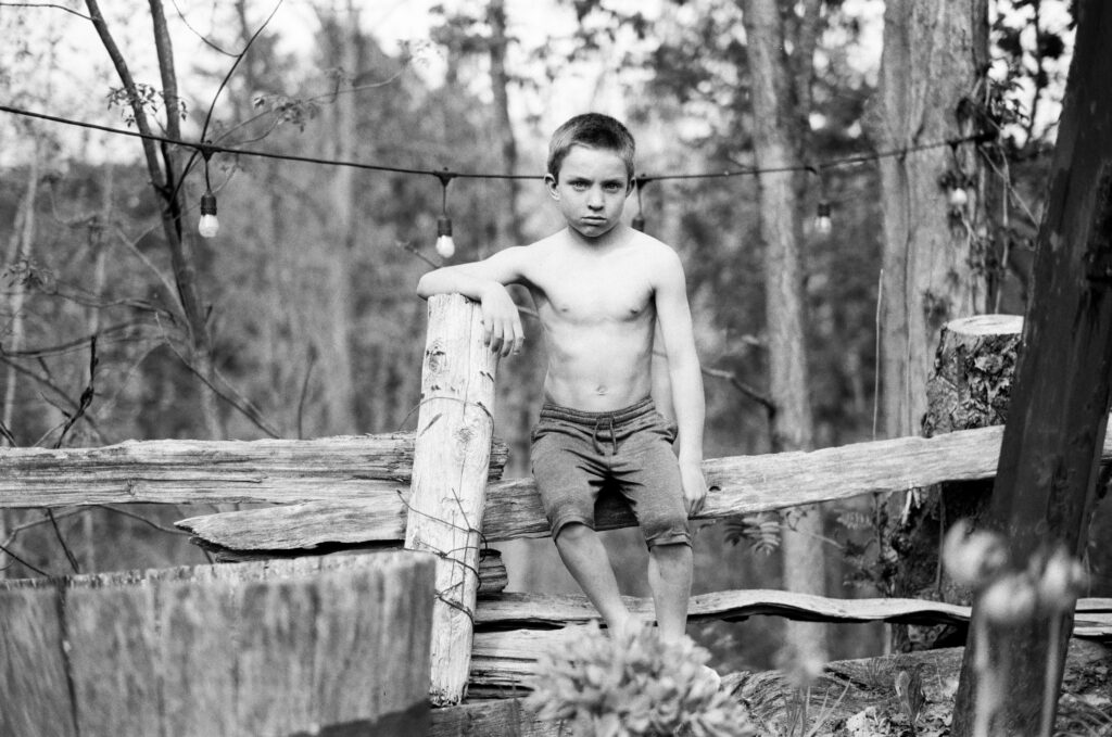 Boy sitting on fence