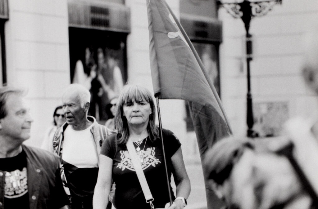 A woman carrying a flag for a street demonstration