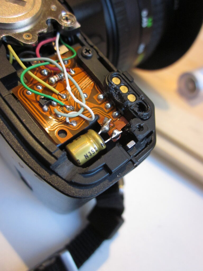 A photograph showing the completed repair with the new capacitor soldered in place