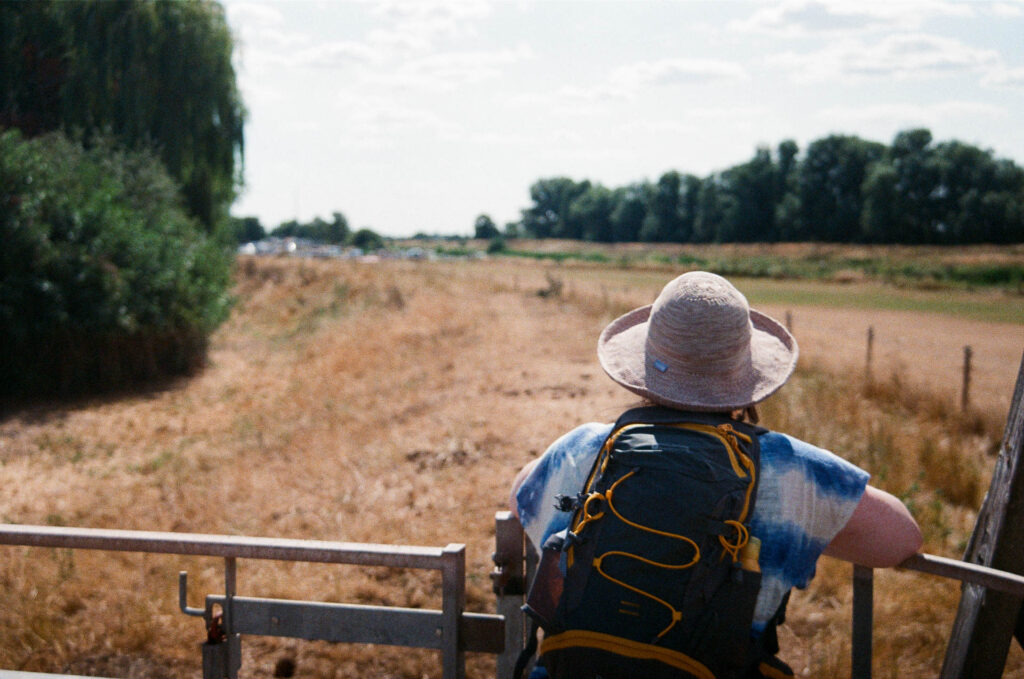 Back of head shot leaning against kissing gate looking at the river bank ahead
