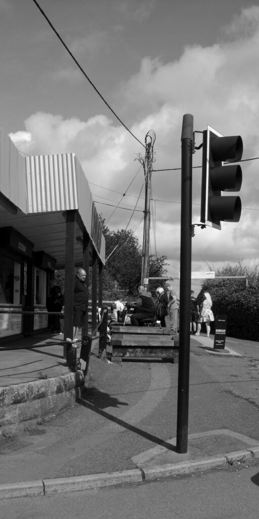 Vertical monochrome image of takeaway shop with customers