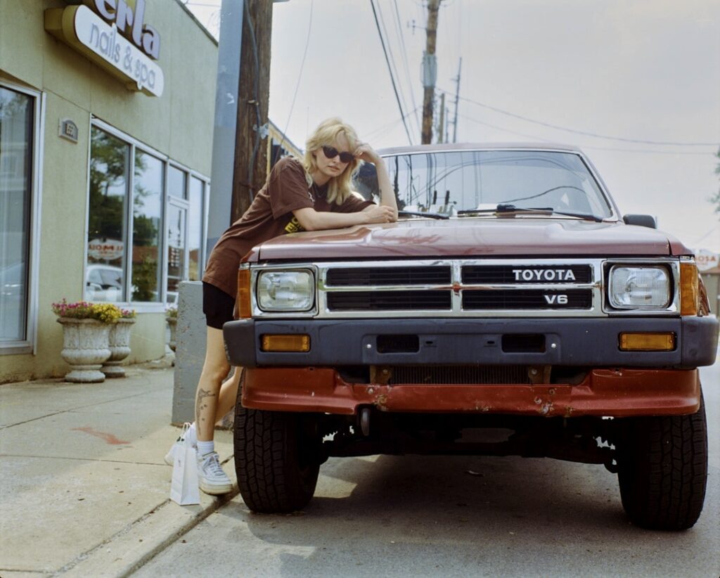 Ellis poses on a Toyota Hilux